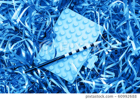 Top view image of bright blue notebook with pencil on background with colorful confetti. 60992688