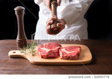 廚師在牛肉上撒胡椒 廚師在牛肉上撒胡椒 60993778