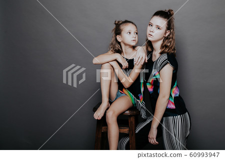 two fashionable girls sisters in beautiful clothes portrait two fashionable girls sisters in beautiful clothes portrait 60993947