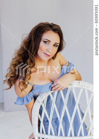 Portrait of a beautiful fashionable woman with hair curls in a blue dress 60995091