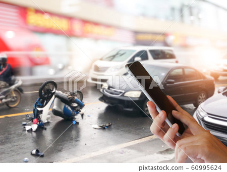 Concept of car accidents, emergency and insurance concept Dangerous traffic on the road, Careless driving car collides with motorcycle. Woman hands using smartphone calling ambulance and car insuranc 60995624