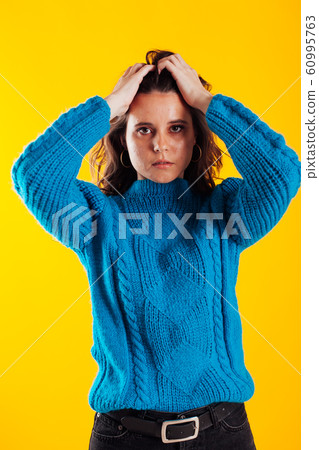 Portrait of a beautiful fashionable brunette woman in a blue winter sweater 60995763