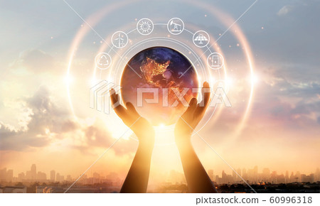 Abstract palm hands touching earth at night on sunset city background. Earth day. Energy saving concept, Elements of this image furnished by NASA 60996318
