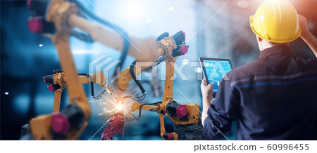 Engineer check and control welding robotics automatic arms machine in intelligent factory automotive industrial with monitoring system software. Digital manufacturing operation. Industry  60996455