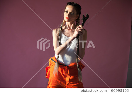 portrait of a beautiful woman with a wrench 60998103