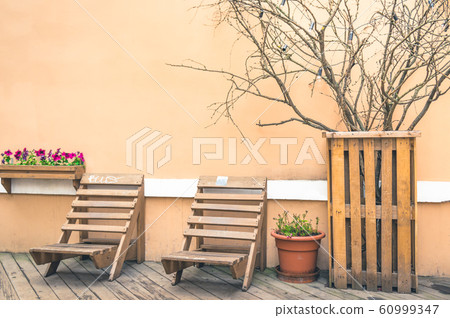 Loft style veranda with two wooden deckchairs on 60999347