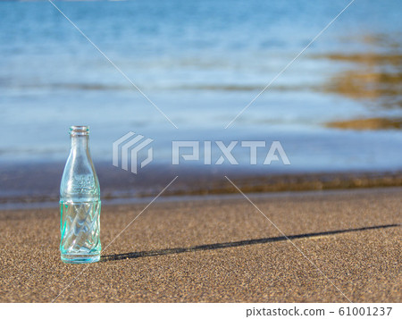 Empty bottle on waterside Empty bottle on waterside 61001237