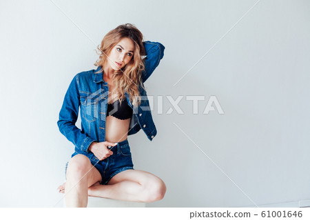 portrait of a beautiful fashionable woman in a denim jacket and shorts portrait of a beautiful fashionable woman in a denim jacket and shorts 61001646