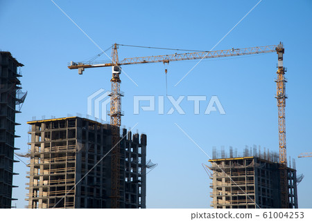 Hydraulic luffing jib tower cranes and workers being poured concrete into foundation. Hydraulic luffing jib tower cranes and workers being poured concrete into foundation. 61004253