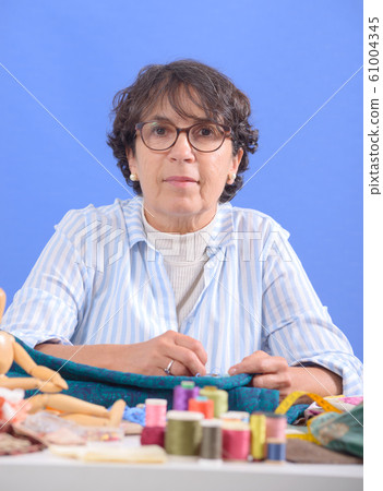 mature brunette woman sewing patchwork 61004345