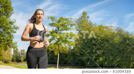 Beautiful young woman run in nature 61004389