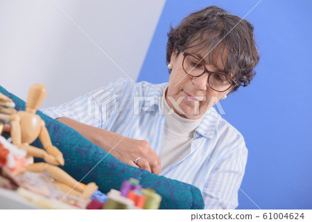 mature brunette woman sewing patchwork mature brunette woman sewing patchwork 61004624
