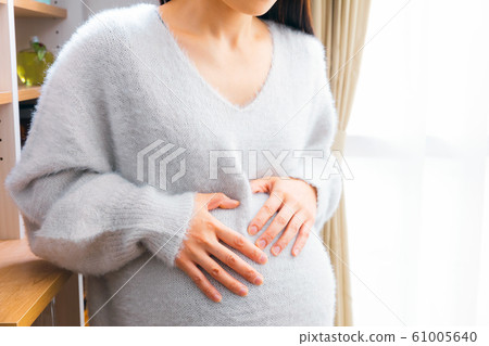 Pregnant woman with a stomach Pregnant woman with a stomach 61005640