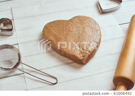 raw dough in shape of heart on the table 61006492