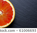 Cut blood orange on dark board, top view 61006693