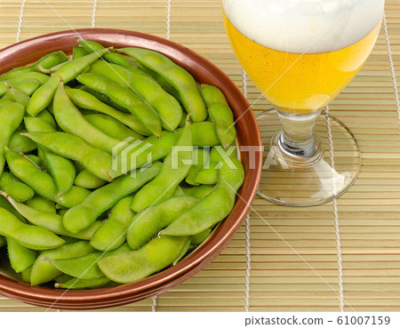 Boiled edamame in a bowl with a glass of beer Boiled edamame in a bowl with a glass of beer 61007159
