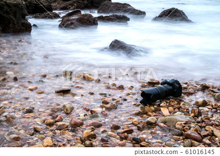 DSLR camera on stone beach wet from water sea wave DSLR camera on stone beach wet from water sea wave 61016145