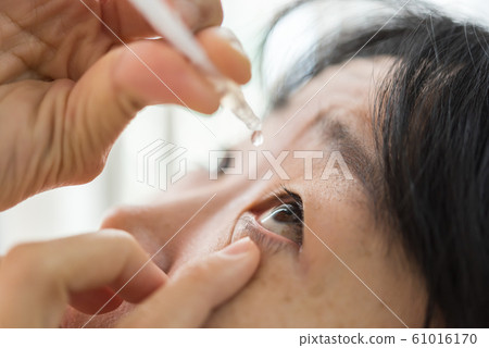 Woman use eye drop, artificial tears to the eye Woman use eye drop, artificial tears to the eye 61016170