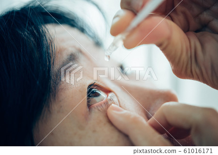 Woman use eye drop, artificial tears to the eye 61016171