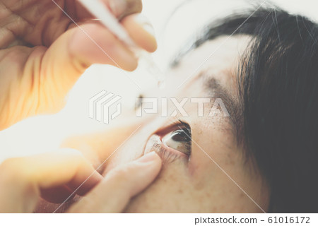 Woman use eye drop, artificial tears to the eye Woman use eye drop, artificial tears to the eye 61016172