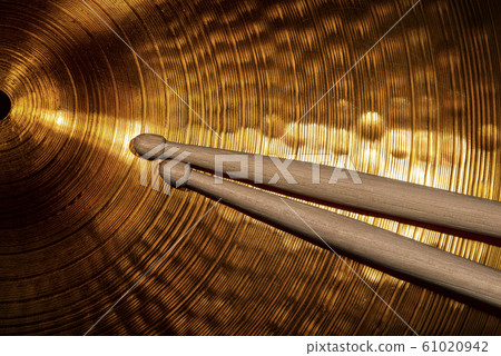Close-up of wooden drumsticks on a golden cymbal 61020942