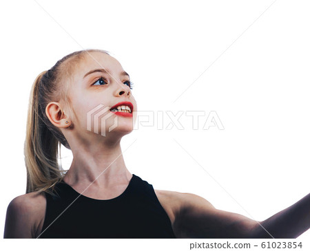 The young gymnast looks enthusiastically during the exercise 61023854