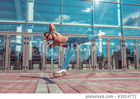 Man dancer, muscle jump in flight, dancing breakdance, summer in city, free space for text, hip-hop break dancer. Youth lifestyle, active, trend modern, fitness sport, positive motivation. 61024772