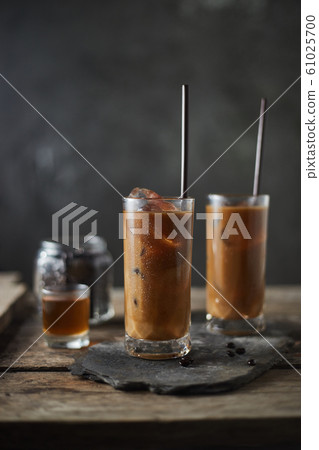 Ice coffee in a tall glass on wooden table.. 61025700