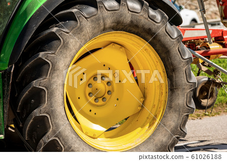 Close-up of a large wheel of a tractor with tire Close-up of a large wheel of a tractor with tire 61026188