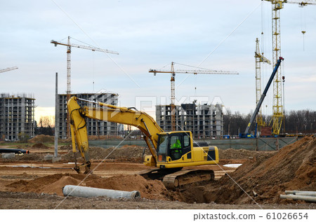 Excavator digs the ground for the foundation and construction of a new building. Excavator digs the ground for the foundation and construction of a new building. 61026654