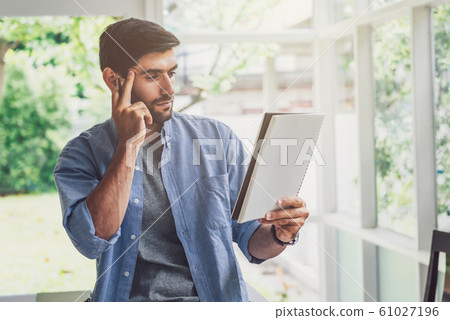 A man looking and thinking at note book A man looking and thinking at note book 61027196