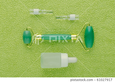 jade facial roller and face serum in ampoules and bottle 61027917