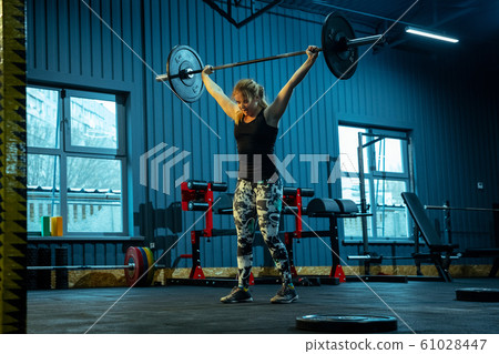 Caucasian teenage girl practicing in weightlifting in gym Caucasian teenage girl practicing in weightlifting in gym 61028447