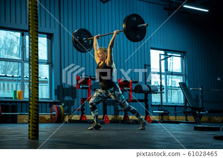 Caucasian teenage girl practicing in weightlifting in gym 61028465