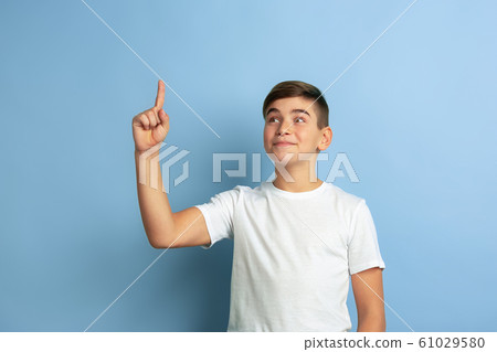 Caucasian teen's portrait isolated on blue studio background 61029580