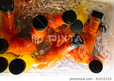 Glass of orange juice soaked in ice buckets Glass of orange juice soaked in ice buckets 61032529