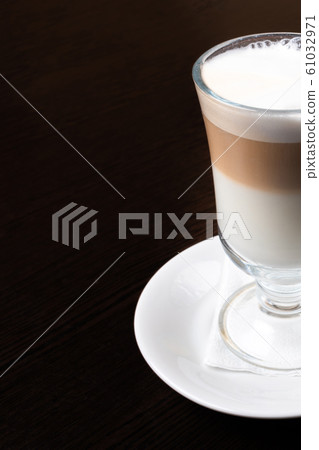 Mug of latte, on a dark, wooden background.  61032971