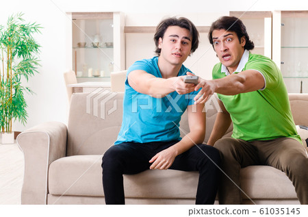 Friends watching football at home Friends watching football at home 61035145