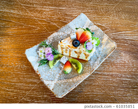 Beautiful cake with fruits placed on the wood table Beautiful cake with fruits placed on the wood table 61035851