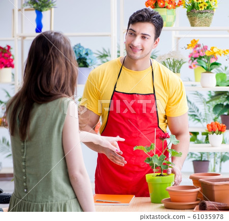 Florist selling flowers in a flower shop Florist selling flowers in a flower shop 61035978
