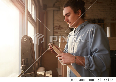 Man working with wood on lathe 61036182