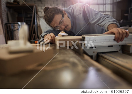 Man measuring the wooden plank 61036297
