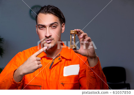 Young convict man sitting in dark room Young convict man sitting in dark room 61037850