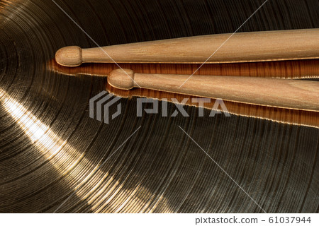 Close-up of wooden drumsticks on a metal cymbal 61037944
