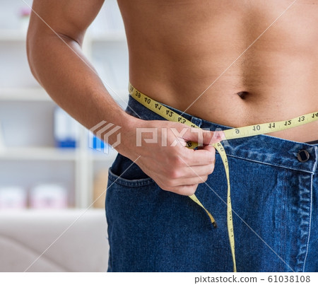Man in oversized pants in weight loss concept Man in oversized pants in weight loss concept 61038108