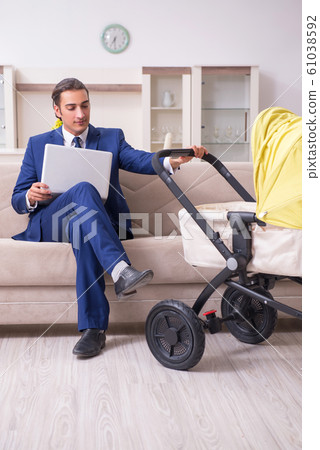 Young businessman looking after baby 61038592