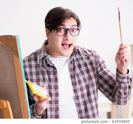 Young male artist drawing pictures in bright studio 61038805