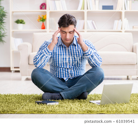 Young handsome man sitting on floor at home 61039541