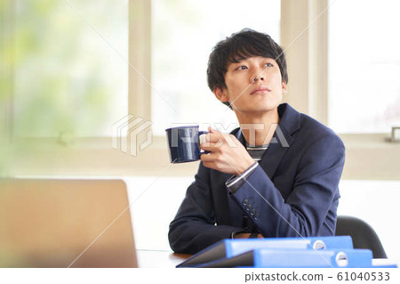 Young man relaxing at desk 61040533