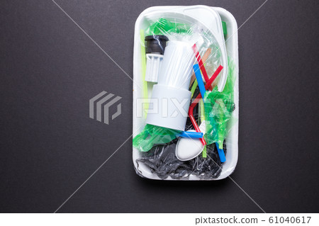 Set of plastic waste in a packed tray on a black isolated background. The problem of ecology and environmental pollution. 61040617